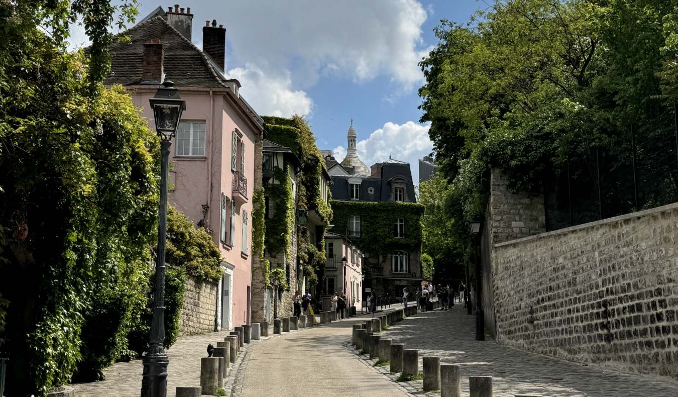 A winding street with an Instagram-famous pink house in the neighborhood of Montmartre, Paris